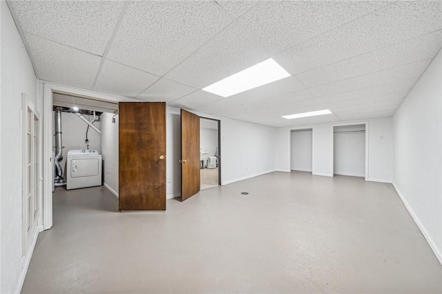 finished basement with separate washer and dryer, baseboards, and a paneled ceiling