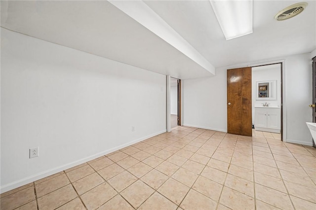 spare room featuring light tile patterned floors, baseboards, and visible vents
