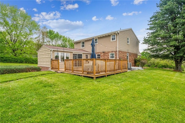 rear view of property with a lawn, brick siding, central air condition unit, and a deck