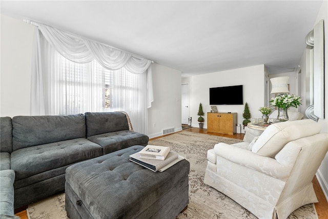living area with visible vents, baseboards, and light wood-type flooring