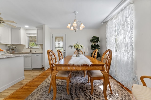 dining area featuring recessed lighting, light wood finished floors, ceiling fan with notable chandelier, and baseboards