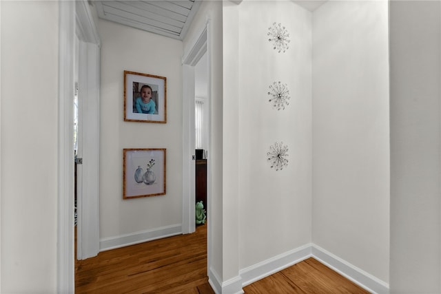 hall with baseboards and wood finished floors