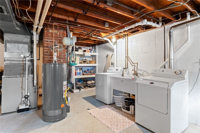 unfinished below grade area with a sink, heating unit, gas water heater, and washer and dryer