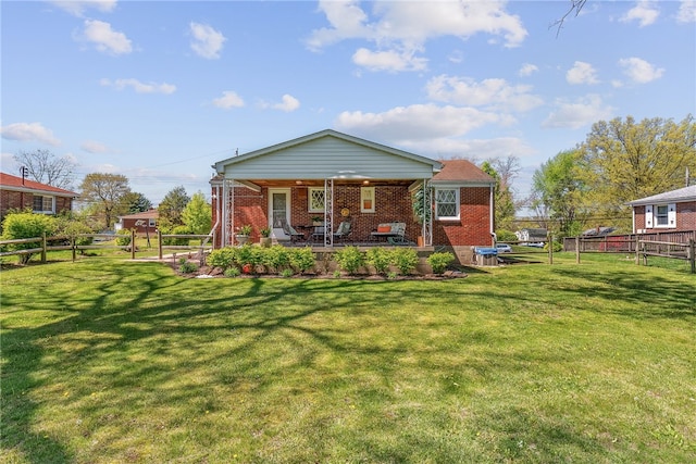 rear view of property featuring a lawn, a fenced backyard, and brick siding