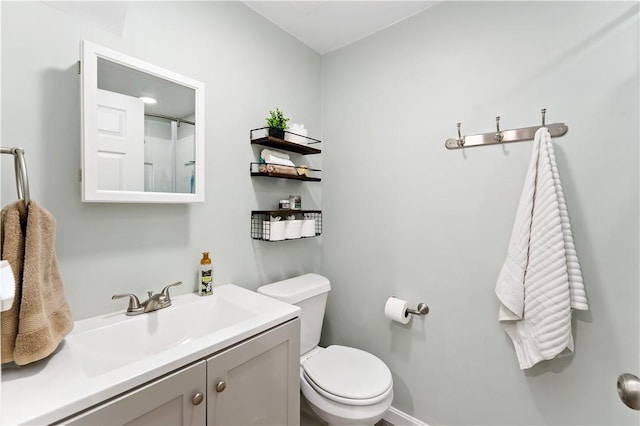 bathroom with vanity, baseboards, and toilet