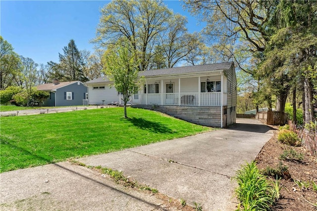single story home with covered porch, concrete driveway, and a front yard