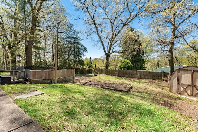 view of yard with an outdoor structure, a shed, and a fenced backyard