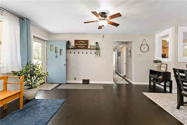 foyer with a ceiling fan, baseboards, visible vents, and dark wood-type flooring