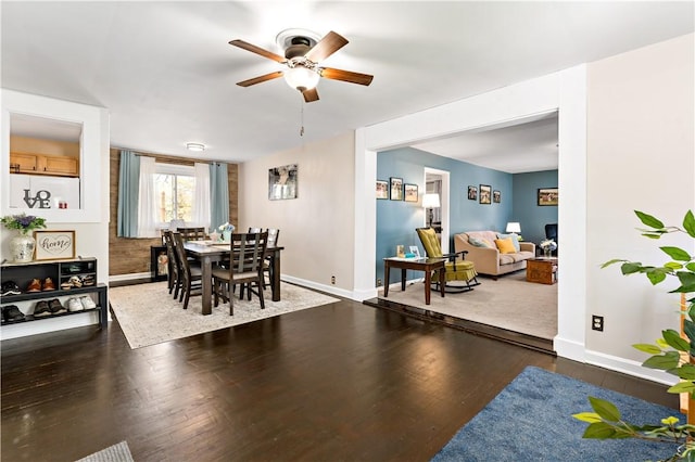 dining area featuring baseboards, ceiling fan, and wood finished floors