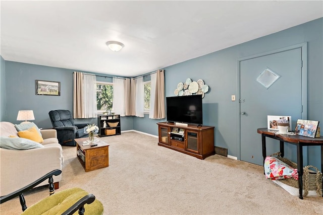 carpeted living area featuring baseboards