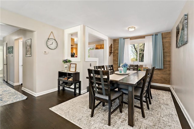 dining space with baseboards and wood finished floors