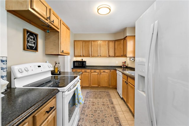 kitchen with light tile patterned floors, dark countertops, and white appliances