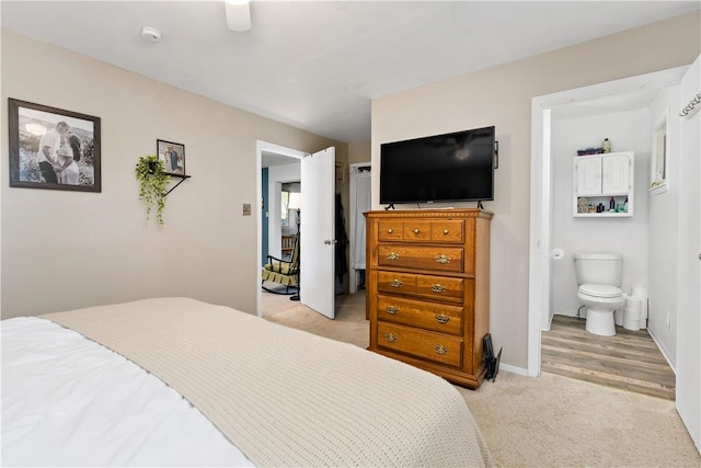 bedroom featuring baseboards, ceiling fan, connected bathroom, and light colored carpet