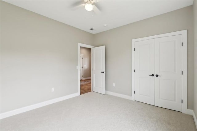 unfurnished bedroom with baseboards, carpet, a closet, and visible vents