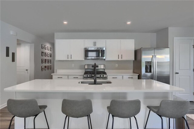 418 Fosse Ct, Lancaster Twp, PA 16037 - kitchen with a kitchen island with sink, a kitchen bar, light countertops, white cabinets, and stainless steel appliances