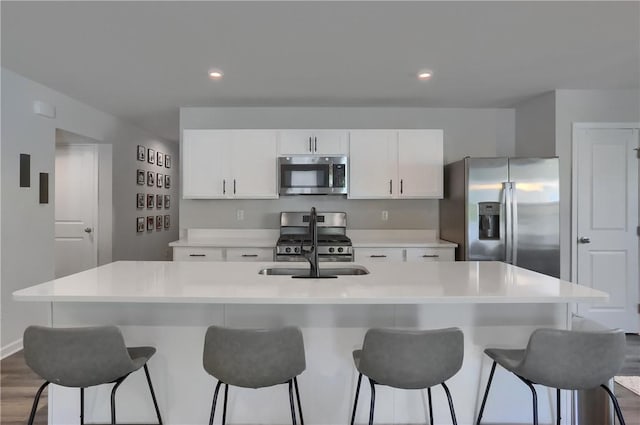 418 Fosse Ct, Lancaster Twp, PA 16037 - kitchen with stainless steel appliances, white cabinetry, a breakfast bar, an island with sink, and light countertops