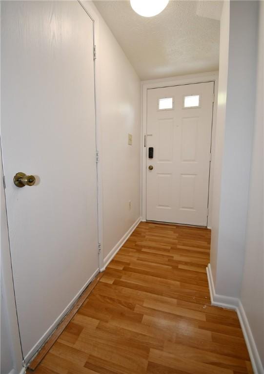 entryway with baseboards and light wood-type flooring