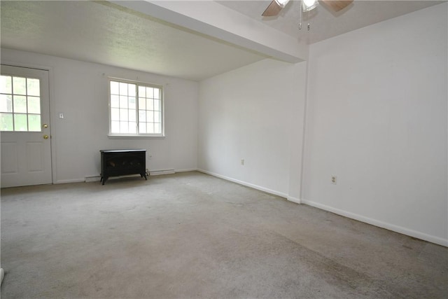 spare room with baseboards, carpet, ceiling fan, and baseboard heating