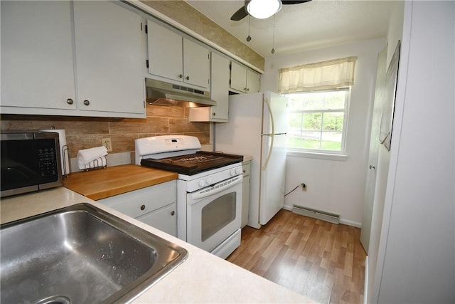 kitchen with a sink, light wood-style floors, white gas range, decorative backsplash, and under cabinet range hood