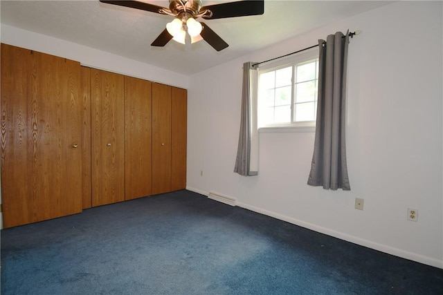 unfurnished bedroom featuring dark carpet, a ceiling fan, baseboards, visible vents, and a closet