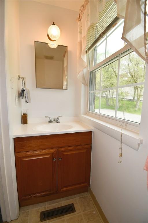 bathroom with tile patterned floors, visible vents, and vanity