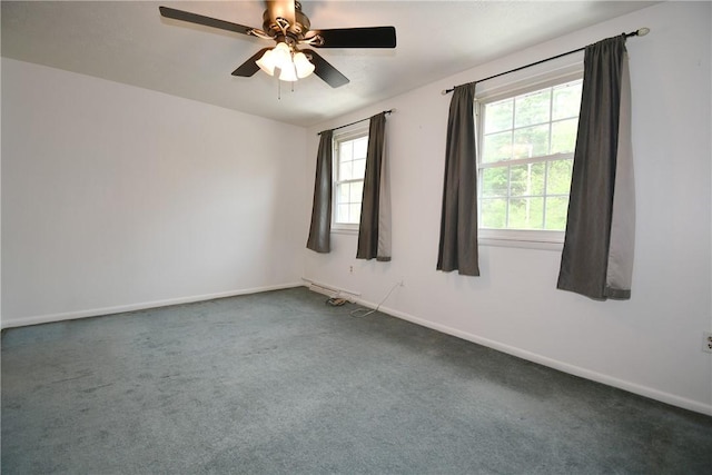 carpeted spare room featuring baseboards and ceiling fan