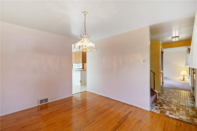 327 Pinehaven Dr, Upper St Clair, PA 15241 - empty room featuring visible vents, wood finished floors, baseboards, a notable chandelier, and stairs