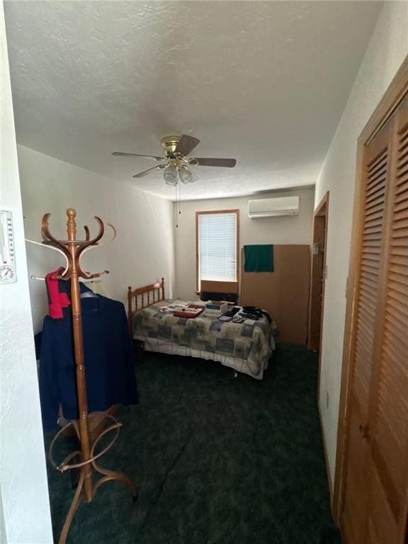 carpeted bedroom featuring an AC wall unit, a textured ceiling, ceiling fan, and a closet