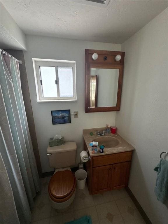 bathroom with a textured ceiling, vanity, baseboards, toilet, and a shower with shower curtain