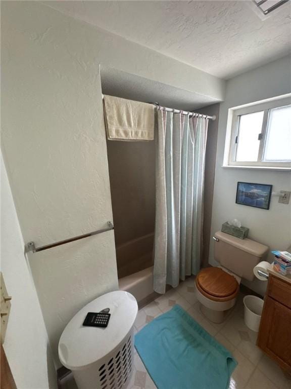 bathroom featuring vanity, a textured ceiling, tile patterned floors, and toilet