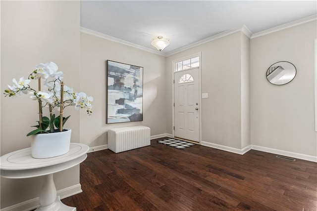 foyer with visible vents, crown molding, wood finished floors, baseboards, and radiator heating unit