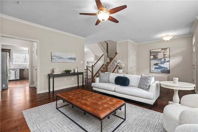 living room with ceiling fan, wood finished floors, stairway, baseboards, and ornamental molding