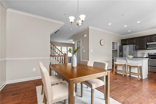 dining room with crown molding, stairs, wood finished floors, a notable chandelier, and recessed lighting