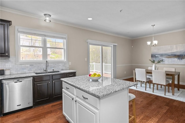 kitchen with backsplash, dark wood finished floors, dishwasher, a sink, and an inviting chandelier