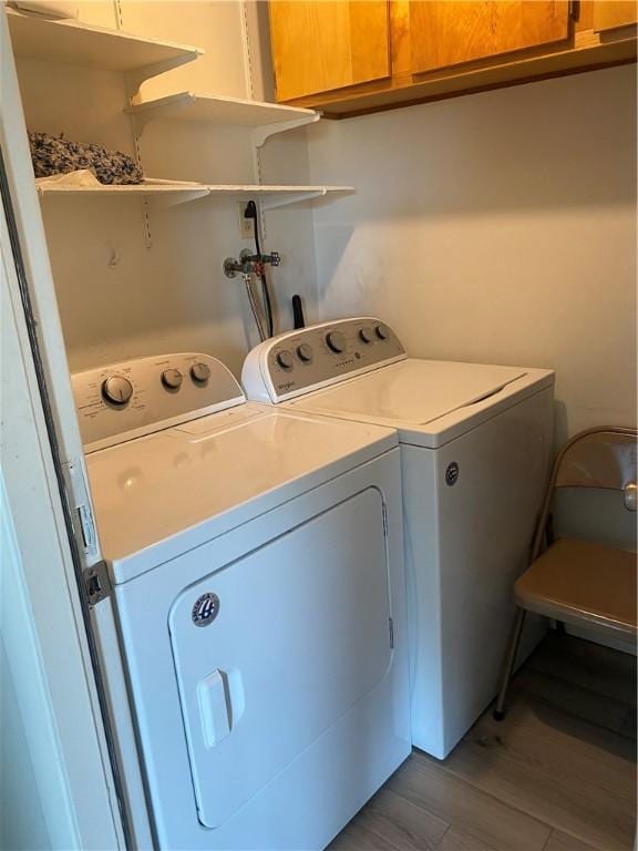washroom featuring cabinet space, light wood-style flooring, and washer and dryer