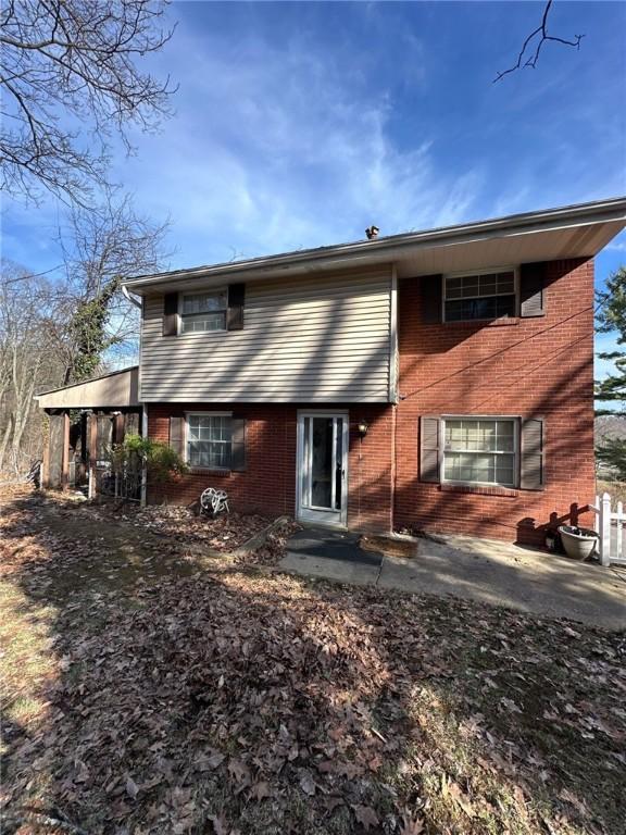 back of house featuring a patio area and brick siding