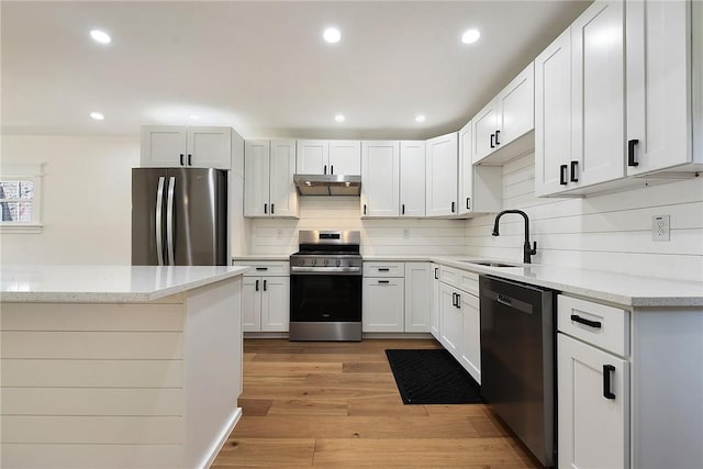1203 Berkshire Ave, Brookline, PA 15226 - kitchen with decorative backsplash, under cabinet range hood, light stone counters, a sink, and appliances with stainless steel finishes