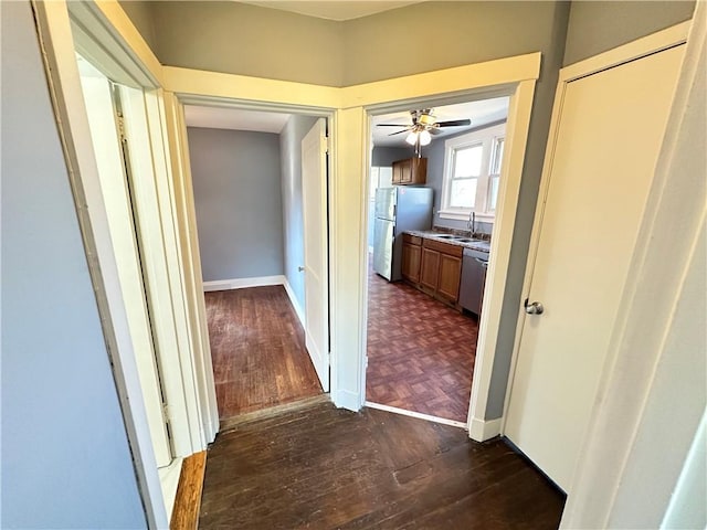 corridor featuring dark wood-style floors and a sink