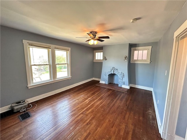 unfurnished living room featuring ceiling fan, visible vents, dark wood-style floors, and baseboards