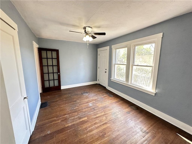 spare room featuring baseboards, visible vents, ceiling fan, and hardwood / wood-style flooring