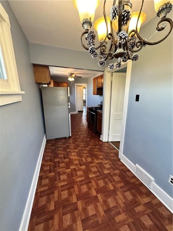 interior space with visible vents, baseboards, and a chandelier