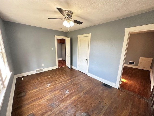 unfurnished bedroom with baseboards, wood finished floors, and visible vents