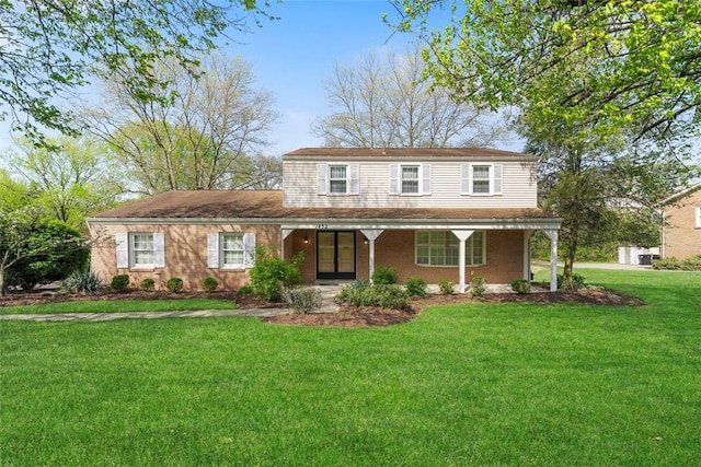 traditional-style home featuring a front lawn and covered porch