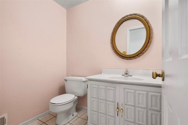 bathroom with toilet, tile patterned floors, baseboards, and vanity