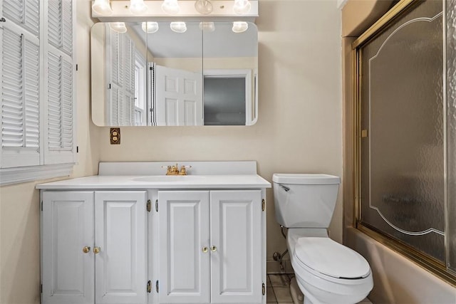 bathroom with toilet, shower / bath combination with glass door, and vanity