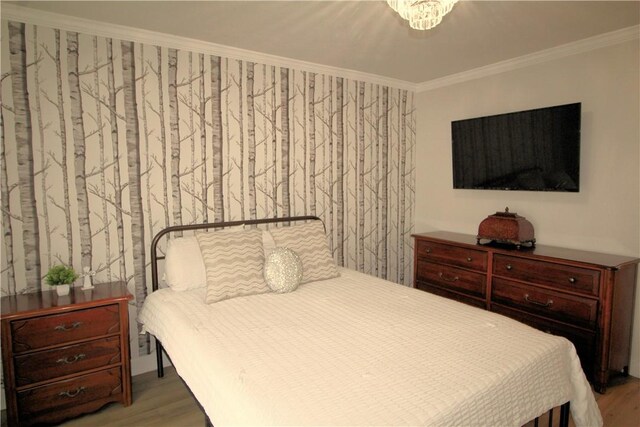 bedroom featuring ornamental molding and wood finished floors
