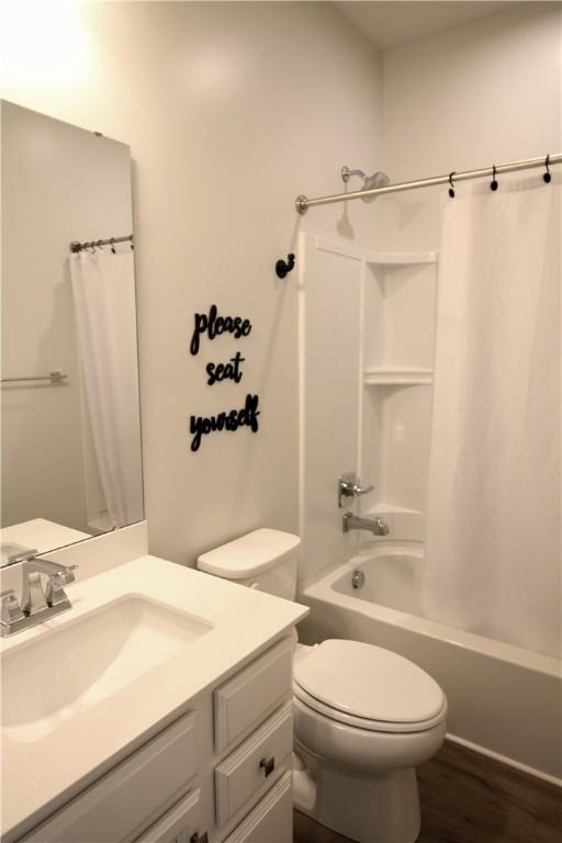 full bathroom featuring vanity, shower / bath combo, toilet, and wood finished floors