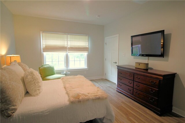 bedroom with baseboards and light wood-type flooring