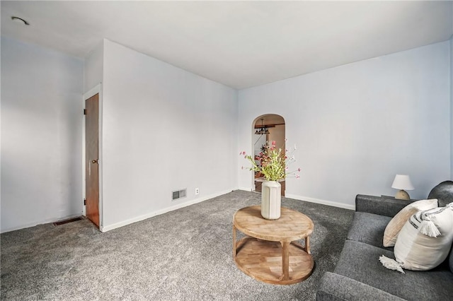 carpeted living room featuring arched walkways, baseboards, and visible vents