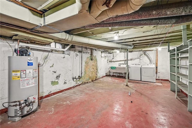 unfinished basement with a sink, water heater, and independent washer and dryer